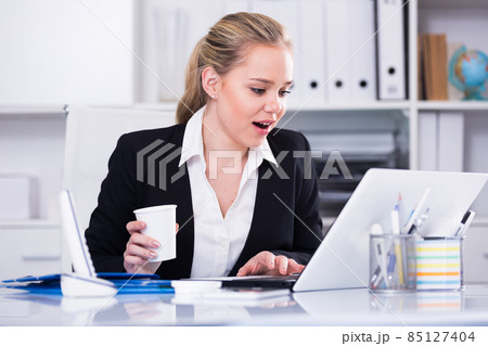 Surprised businesswoman looking at monitor 85127404
