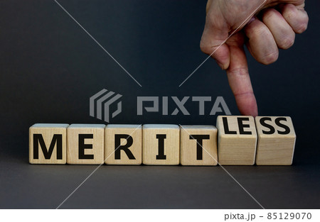 Merit or meritless symbol. Businessman turns wooden cubes and changes the word meritless to merit. Beautiful grey table, grey background. Business and merit or meritless concept. Copy space. Merit or meritless symbol. Businessman turns wooden cubes and changes the word meritless to merit. Beautiful grey table, grey background. Business and merit or meritless concept. Copy space. 85129070