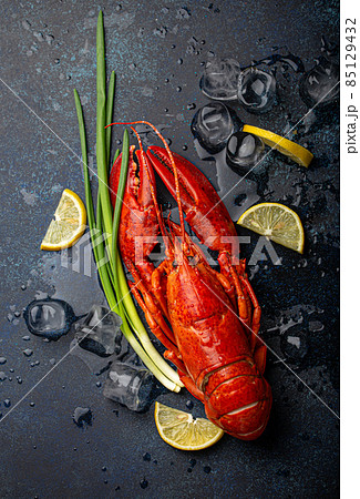 Lobster with lemon and ice cubes top view on blue stone background 85129432