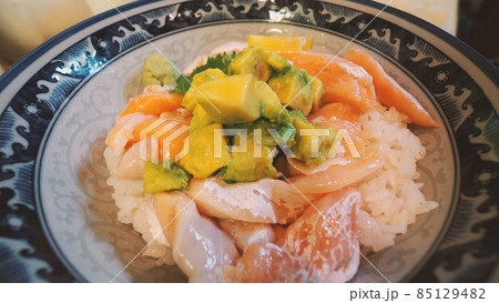 Close up images of japanese seafood rice bowl or kaisendon sashimi donburi or KAISEN CHIRASHI DON which have raw fresh ogura uni shrimp crab and fish on rice bowl. wood table from top view angle. 85129482