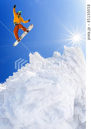 Snowboarder jumping against blue sky in high mountains 85130058