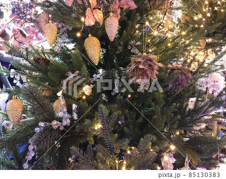 Festive Christmas border, isolated on white background. Fir green branches are decorated with red stars, berries, fir cones and red toy deer, close-up Festive Christmas border, isolated on white background. Fir green branches are decorated with red stars, berries, fir cones and red toy deer, close-up 85130383