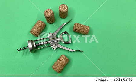 Steel wine corkscrew together with wooden corks lie on the chromakey table Steel wine corkscrew together with wooden corks lie on the chromakey table 85130840