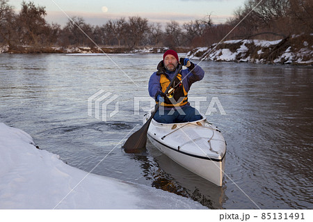 paddling canoe on a winter river 85131491
