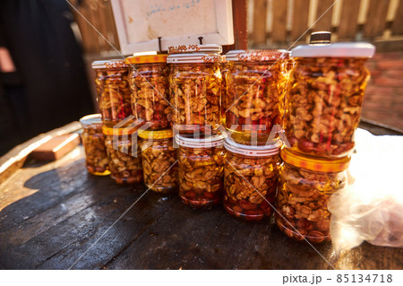 Assortment of honey jars at market stall. Sale of natural honey in fair outdoor. Production of honey Assortment of honey jars at market stall. Sale of natural honey in fair outdoor. Production of honey 85134718