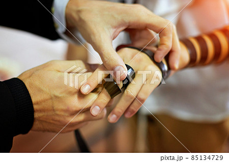 Detail of a moment when a Jewish rabbi puts tefillin on the arm of a thirteen year old boy to say a prayer before the bar mitzvah Detail of a moment when a Jewish rabbi puts tefillin on the arm of a thirteen year old boy to say a prayer before the bar mitzvah 85134729