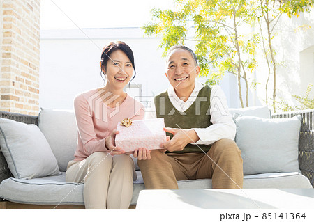 プレゼントの箱を持つシニア夫婦 85141364