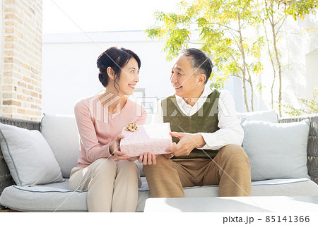 プレゼントの箱を持つシニア夫婦 プレゼントの箱を持つシニア夫婦 85141366