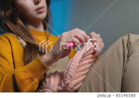 Close-up of young female hands of a Caucasian girl doing crochet, shows how to knit correctly. Shallow depth of field. high dynamic range. 85146580