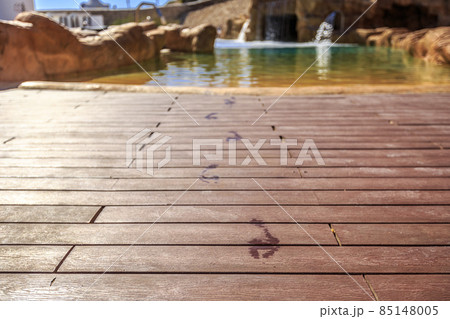 Closeup footprints on the wooden floor behind it swimming pool Closeup footprints on the wooden floor behind it swimming pool 85148005