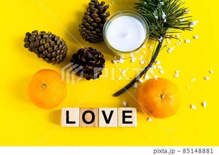 Word LOVE on wooden blocks on yellow background with tangerine. Healthy food concept Word LOVE on wooden blocks on yellow background with tangerine. Healthy food concept 85148881