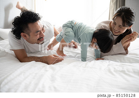 アグレッシブにお動く赤子に笑ってしまう夫婦の写真素材 [85150128