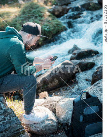 A young man is resting with a phone 85152305
