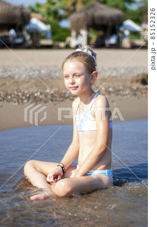 Little girl playing on the beach by the sea 85152326