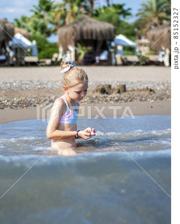 Little girl playing on the beach by the sea 85152327