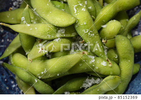 Organic steamed Japanese Edamame, a young soybean that is rich in nutrients served in blue bowl  and sprinkled with sea salt flakes. Vegetables Background. Healthy eating concept 85152369