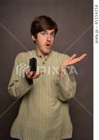 Man holding crystal on grey background 85154258
