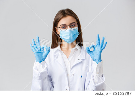 Covid-19, preventing virus, health, healthcare workers and quarantine concept. Professional doctor, physician in personal protective equipment, medical mask and gloves, show okay sign, guarantee 85155797