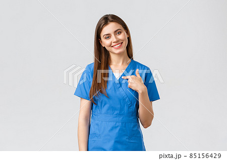Healthcare workers, prevent virus, insurance and medicine concept. Pleasant smiling pretty nurse, female doctor in blue scrubs, pointing herself, ready help, saving patients Healthcare workers, prevent virus, insurance and medicine concept. Pleasant smiling pretty nurse, female doctor in blue scrubs, pointing herself, ready help, saving patients 85156429