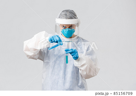 Covid-19, medical research, diagnosis, healthcare workers and quarantine concept. Shocked and excited doctor working on new coronavirus vaccine, pouring liquid in test-tube, stare intense Covid-19, medical research, diagnosis, healthcare workers and quarantine concept. Shocked and excited doctor working on new coronavirus vaccine, pouring liquid in test-tube, stare intense 85156709