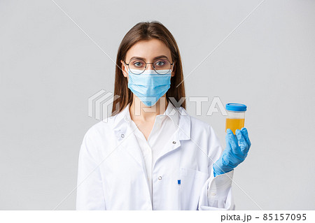 Covid-19, medical research, diagnosis, healthcare workers and quarantine concept. Doctor in clinic lab working with patient urine sample, making test find coronavirus infection, grey background 85157095