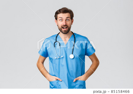 Covid-19, quarantine, hospitals and healthcare workers concept. Surprised and amused doctor in scrubs with stethoscope looking excited hearing good news, have chat, conversation Covid-19, quarantine, hospitals and healthcare workers concept. Surprised and amused doctor in scrubs with stethoscope looking excited hearing good news, have chat, conversation 85158466