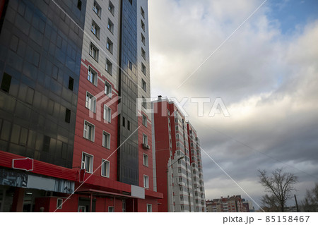 The facade of a residential building on a background of blue sky with clouds. The facade of a residential building on a background of blue sky with clouds. 85158467