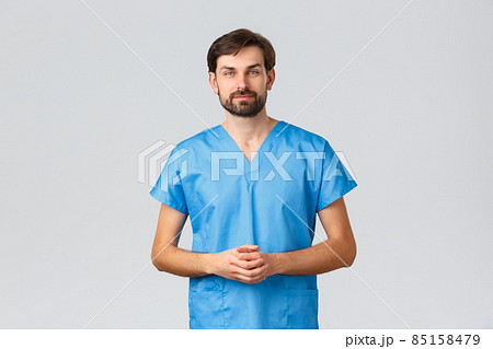 Healthcare workers, coronavirus quarantine campaign and pandemic concept. Prodessional male doctor, bearded guy working nurse clinic, helping patient deal with injury, hear out in ER 85158479