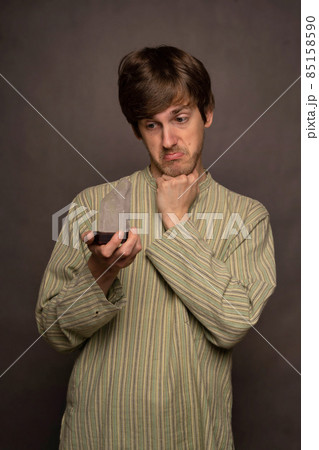 Man holding crystal on grey background Man holding crystal on grey background 85158590