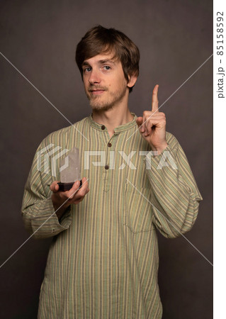 Man holding crystal on grey background Man holding crystal on grey background 85158592