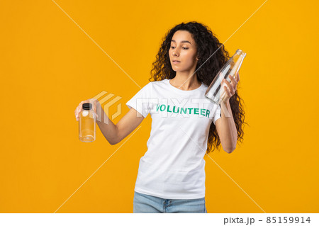 Volunteer Lady Choosing Glass Bottle Instead Of Plastic, Yellow Background 85159914