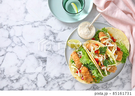 Yummy fish tacos served on white marble table, flat lay. Space for text Yummy fish tacos served on white marble table, flat lay. Space for text 85161731