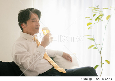 帰宅してビールを飲むミドル男性 85163273