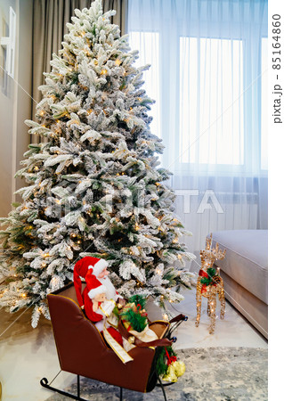 a large Christmas tree, Santa Claus on a sled and a reindeer lamp in a room a large Christmas tree, Santa Claus on a sled and a reindeer lamp in a room 85164860