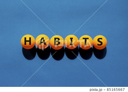 Habits and business symbol. The concept word 'habits' on orange table tennis balls on a beautiful blue background. Business and habits concept. Habits and business symbol. The concept word 'habits' on orange table tennis balls on a beautiful blue background. Business and habits concept. 85165667