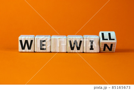 We will win symbol. Turned a wooden cube and changed words we will to we win. Beautiful orange background, copy space. Business, motivational and we will win concept. 85165673