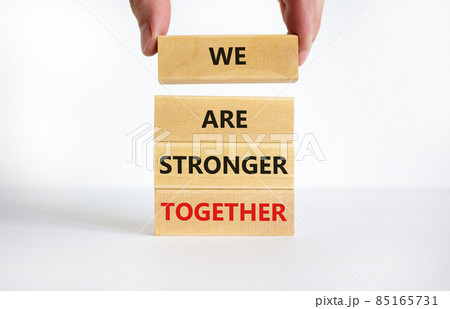 We are stronger together symbol. Concept words We are stronger together on wooden blocks. Businessman hand. Beautiful white background, copy space. Business and we are stronger together concept. 85165731