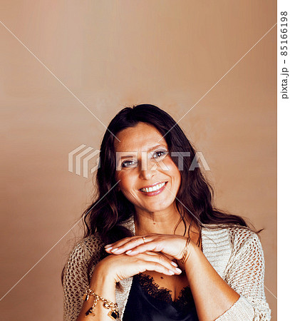 pretty brunette confident mature woman posing cheerful on warm brown background, lifestyle people concept pretty brunette confident mature woman posing cheerful on warm brown background, lifestyle people concept 85166198