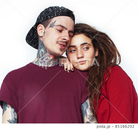 Young couple together. guy with tattoo, girlfriend wearing dreadlocks having fun on white background Young couple together. guy with tattoo, girlfriend wearing dreadlocks having fun on white background 85166202