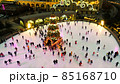 people skate on ice rink around christmas tree 85168710