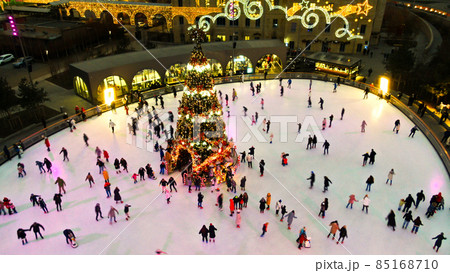 people skate on ice rink around christmas tree 85168710