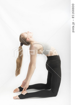 Camel Pose. Ustrasana. Young attractive woman practicing yoga. Slender girl is engaged in gymnastics. Vertical frame Camel Pose. Ustrasana. Young attractive woman practicing yoga. Slender girl is engaged in gymnastics. Vertical frame 85168800