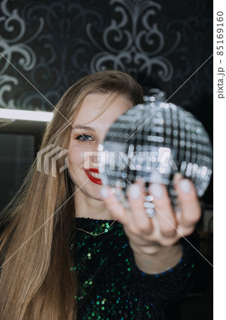 Nightlife, New year eve party, New year celebration. Portrait of young beautiful woman and disco ball 85169160