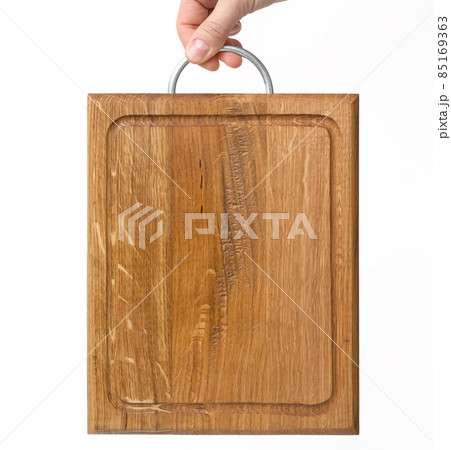female hands hold empty rectangular brown wooden chopping board on white background female hands hold empty rectangular brown wooden chopping board on white background 85169363