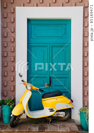 yellow motorcycle at the turquoise wooden door yellow motorcycle at the turquoise wooden door 85169471