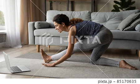 Young female sports trainer show exercise technique online using laptop Young female sports trainer show exercise technique online using laptop 85170635