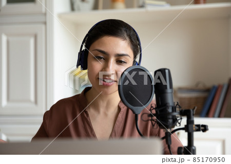 Beautiful young indian woman recording song or voice acting. Beautiful young indian woman recording song or voice acting. 85170950