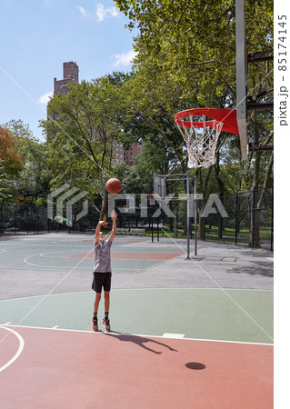 Boy (8-9) playing basketball in park Boy (8-9) playing basketball in park 85174145