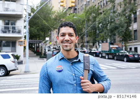 USA, New York, New York City, Portrait of smiling man with vote badge in city USA, New York, New York City, Portrait of smiling man with vote badge in city 85174146