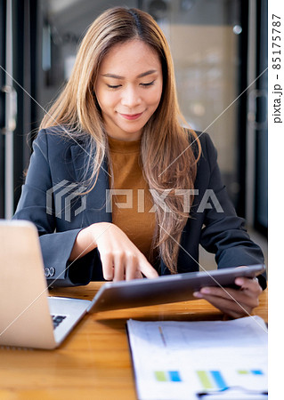 Business Finance and Accounting Concept. Business woman using security application on tablet to protect her money. Business Finance and Accounting Concept. Business woman using security application on tablet to protect her money. 85175787